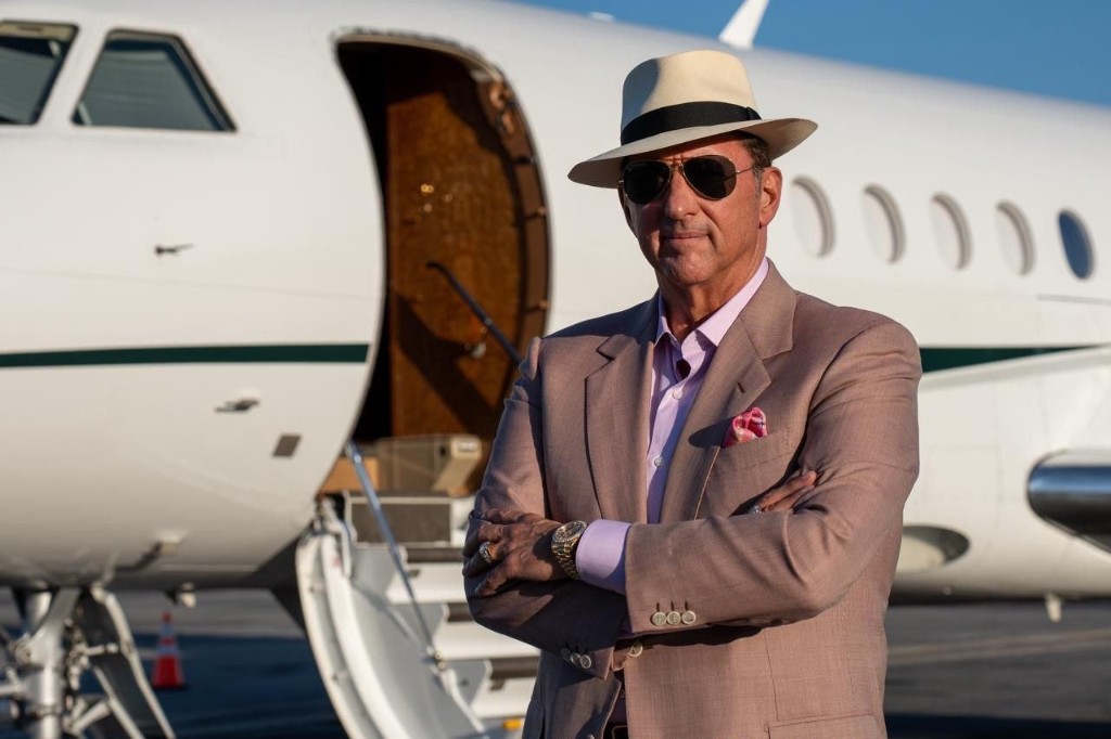 Kevin Trudeau standing in front of a private jet