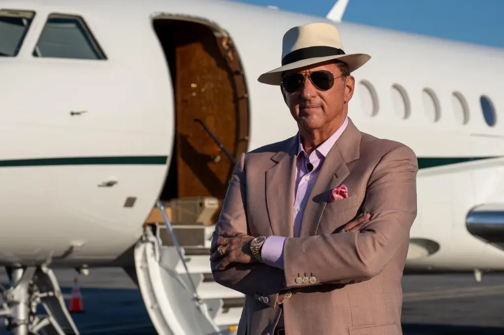 Kevin Trudeau standing in front of a private jet
